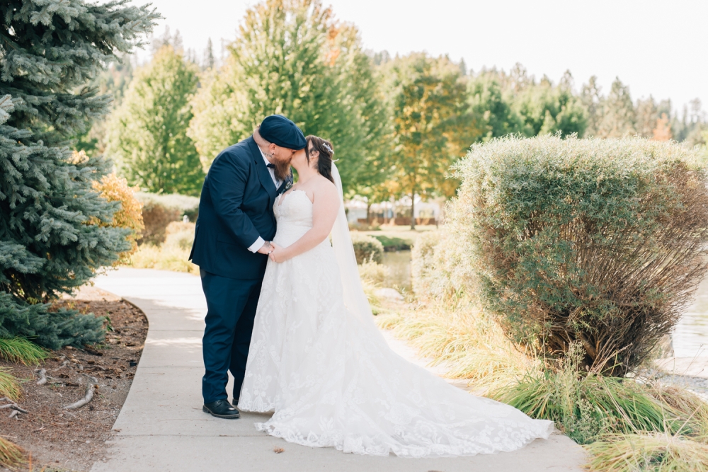 light and airy coeur d'alene wedding photography, bride and groom kissing in Riverstone park
