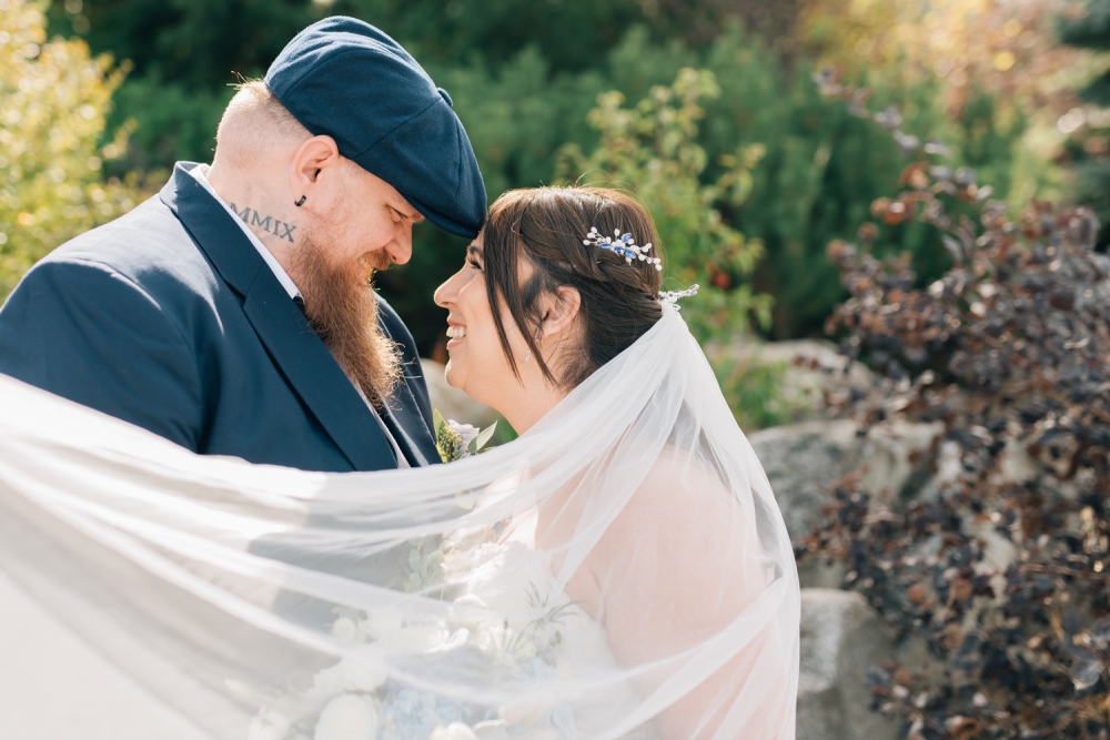coeur d'alene wedding portrait photographer, bride and groom smiling with veil, Riverstone park